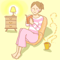 部屋でお茶を飲みながら読書している女性